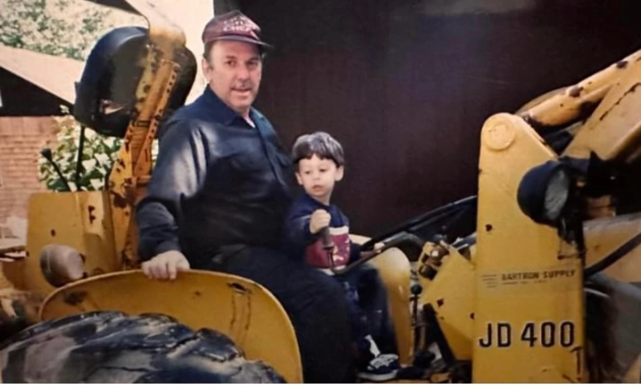 CV Excavation’s owner as a young boy sitting with his Pap on an excavator.